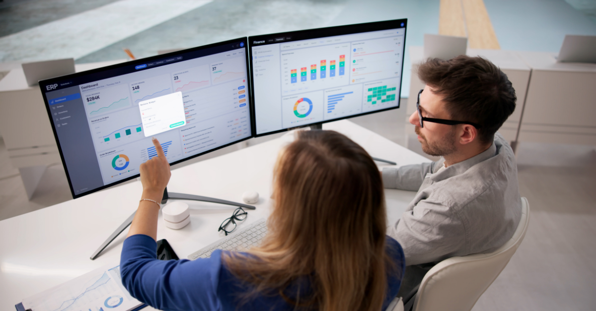 two people conversing in front of a monitor
